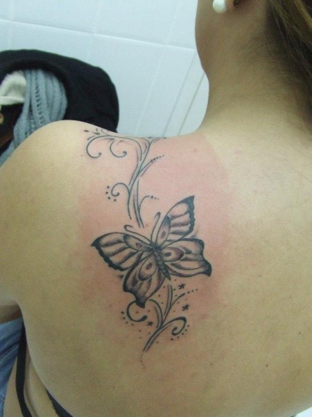 Tatuaje de una mariposa en la espalda de una mujer