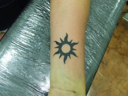 Tatuaje de un pequeño sol en el antebrazo