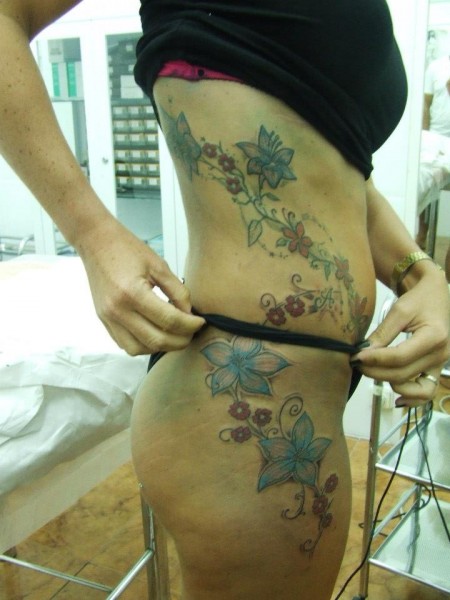 Tatuaje para mujer de unas flores todo el lateral