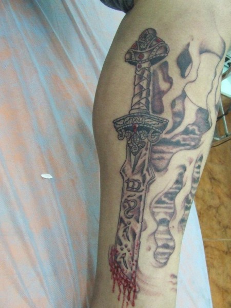 Tatuaje de una espada clavada en la piel