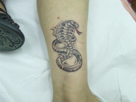 Tatuaje de una cobra en la pierna