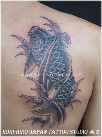 Tatuaje de una carpa entre olas en la espalda