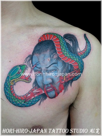 Tatuaje de una serpiente rodeando la cabeza acuchillada de un samurai