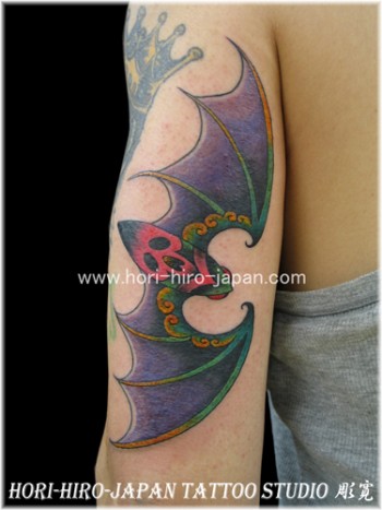 Tatuaje de un murciélago en el brazo