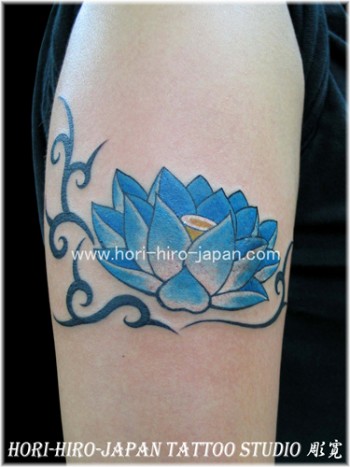 Tatuaje de una flor de loto con un pequeño tribal