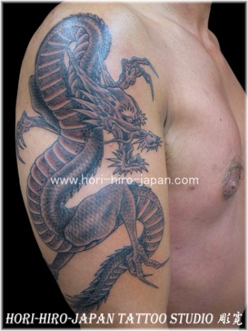 Tatuaje de un dragon en blanco y negro en el brazo