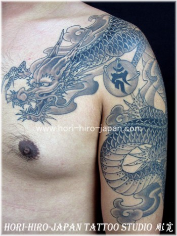 Tatuaje de un dragon que va por el brazo y pecho