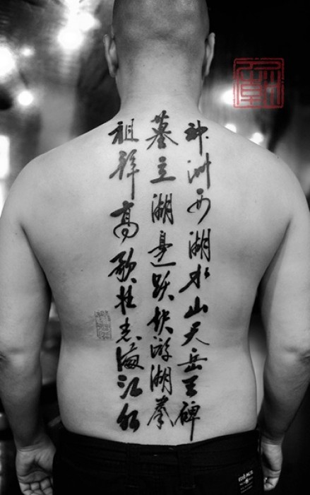 Tatuaje de 3 columnas de kanjis en la espalda