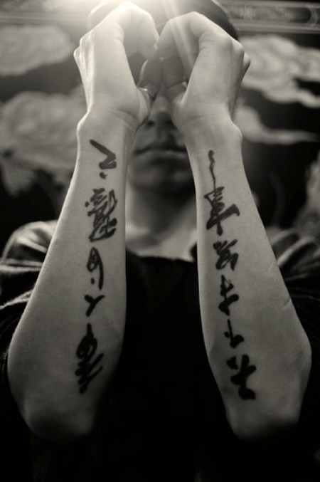 Tatuaje de unos kanjis escritos a pincel en el antebrazo