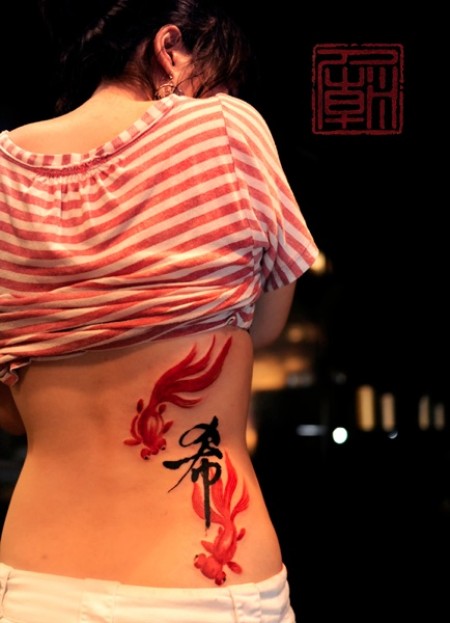 Tatuaje de dos peces chinos y un kanji dibujados con pincel