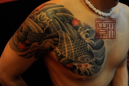 Tatuaje de una carpa koi bajando hacia el pecho