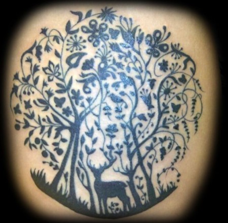 Tatuaje de un ciervo dentro de un frondoso bosque