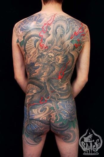 Tatuaje japonés de espalda entera. Un dragón entre humo
