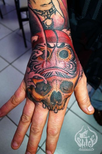 Tatuaje en la mano, de calavera Daruma por cerebro.