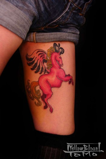 Tatuaje de pony con corona y alas en la pierna.