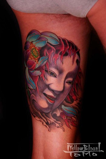 Tatuaje de la cara de una geisha con unas flores