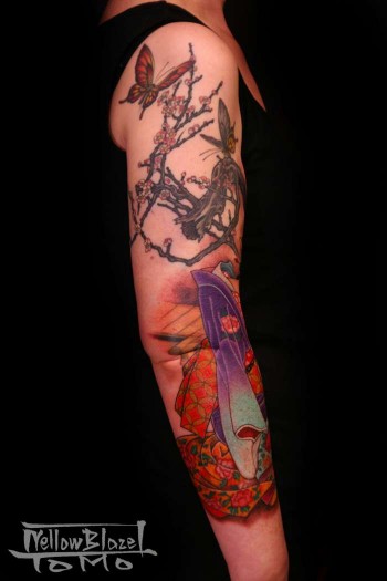 Tatuaje de unas mariposas revoloteando entre las ramas de un árbol