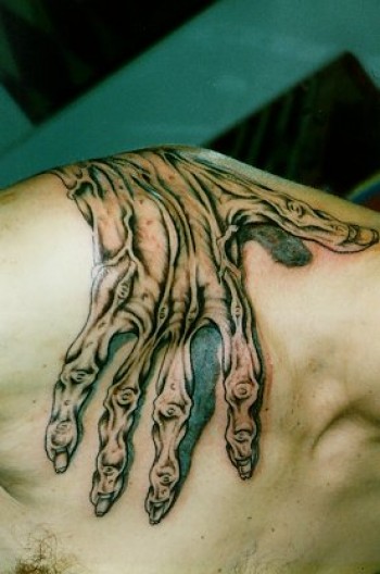 Tatuaje de una mano zombie por encima del hombro