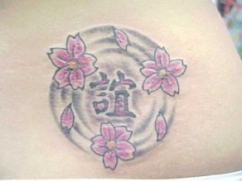 Tatuaje de un kanji en el agua, flotando junto unas flores