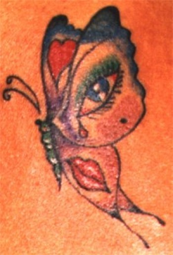 Tatuaje de una mariposa con una cara en sus alas