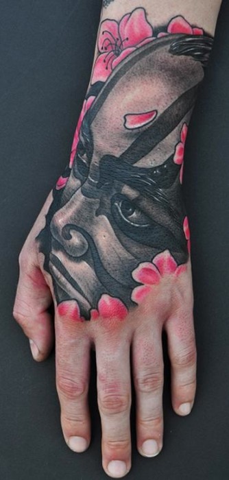 Tatuaje de una cara samurai en la mano