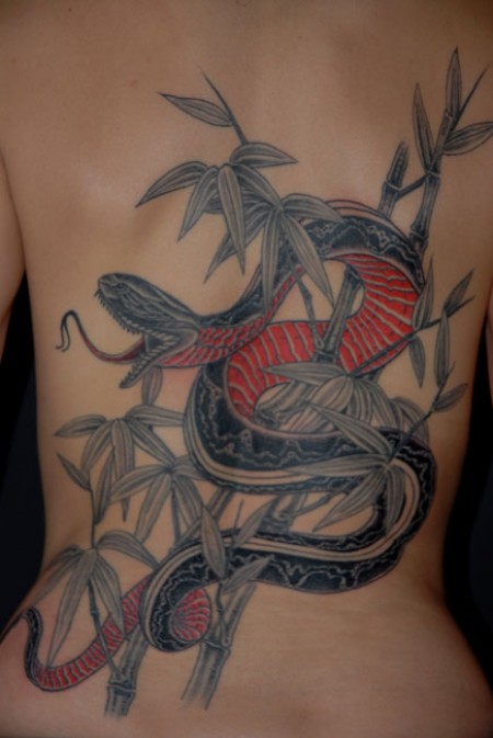 Tatuaje de una serpiente entre ramas