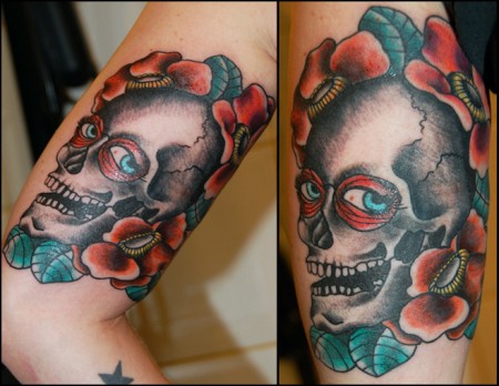 Tatuaje de una calavera con ojos rodeada de flores