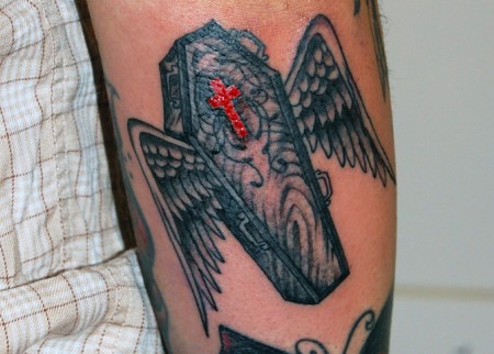 Tatuaje de un ataúd con alas
