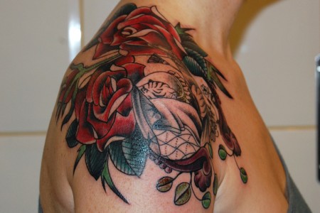 Tatuajes de rosas en el hombro y un tigre blanco escondido entre ellas