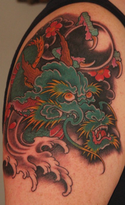 Tatuaje de un dragón con una bola de cristal