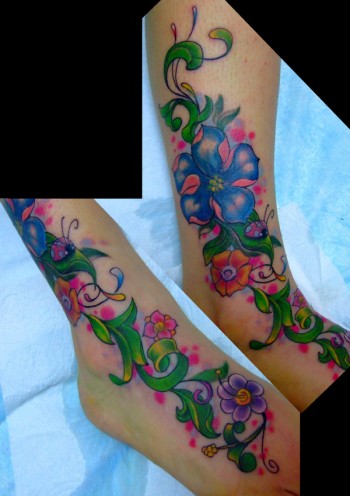 Tatuaje de flores subiendo por la pierna con una mariquita