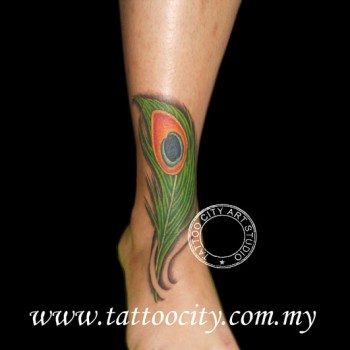 Tatuaje de una pluma de pavo real en el tobillo