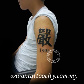 Tatuaje de una letra china y un año en el brazo