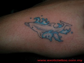 Tatuaje de un delfín chapoteando en el agua