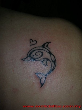 Tatuaje de un delfín estilo maorí con un corazón