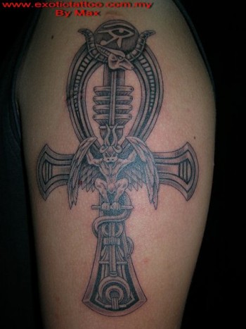 Tatuaje de una cruz ansada egipcia con una gárgola dentro y un ojo de horus encima
