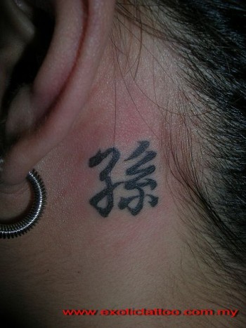Tatuaje de un pequeño kanji detrás de la oreja