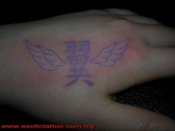Tatuaje en la mano de unas letras en chino con alas