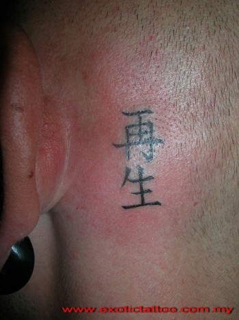 Tatuaje de un nombre en chino detrás de la oreja