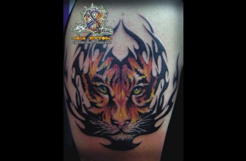 Tatuaje de una cara de tigre dentro de la forma de unas llamas