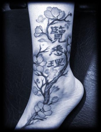 Tatuaje de un cerezo en flor con algunas letras chinas