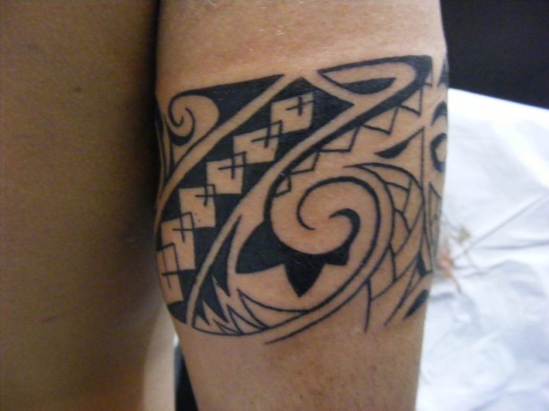 Tatuaje de un brazalete tribal en el antebrazo