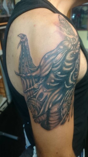 Tatuaje de un dragón saliendo del brazo