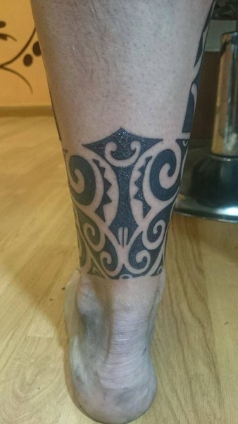 Tatuaje de un brazalete tribal maorí en la pierna