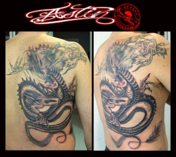 Tatuaje de un dragón en blanco y negro ocupando media espalda