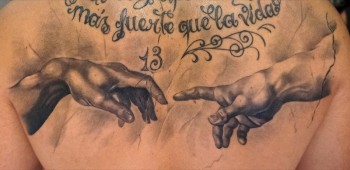 Tatuaje de las manos de la capilla sixtina y una frase en la espalda