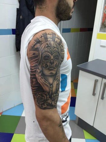 Tatuaje de una calavera mexicana en el brazo de un hombre