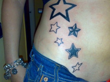 Estrellas con diferente fondo tatuadas en la cintura