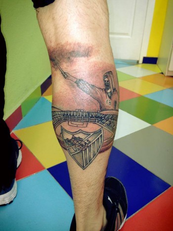Tatuaje de un estadio de fútbol con un escudo