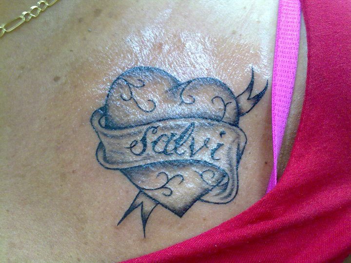 Tatuaje de un corazón y una cinta con un nombre